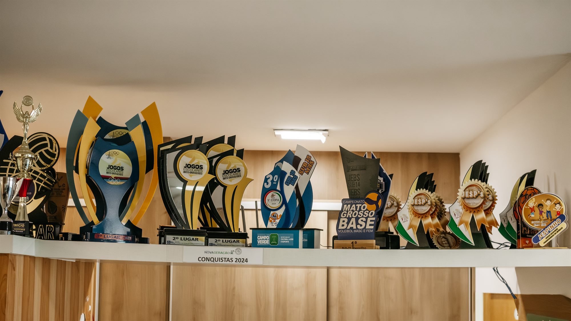 Prateleira de troféus conquistados pela escola
